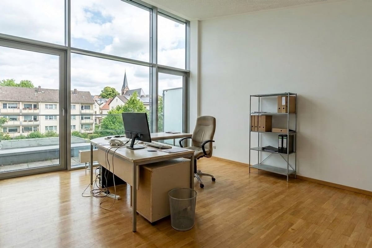 Handyfoto eines alten Büros mit Glasfassade, altem Schreibtisch und Aktenregal